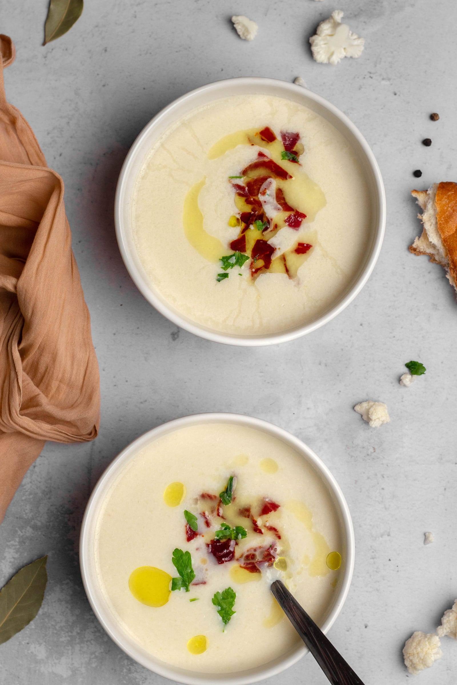 Zwei Schalen cremige Blumenkohlsuppe mit Kräutern und Gewürzen von oben