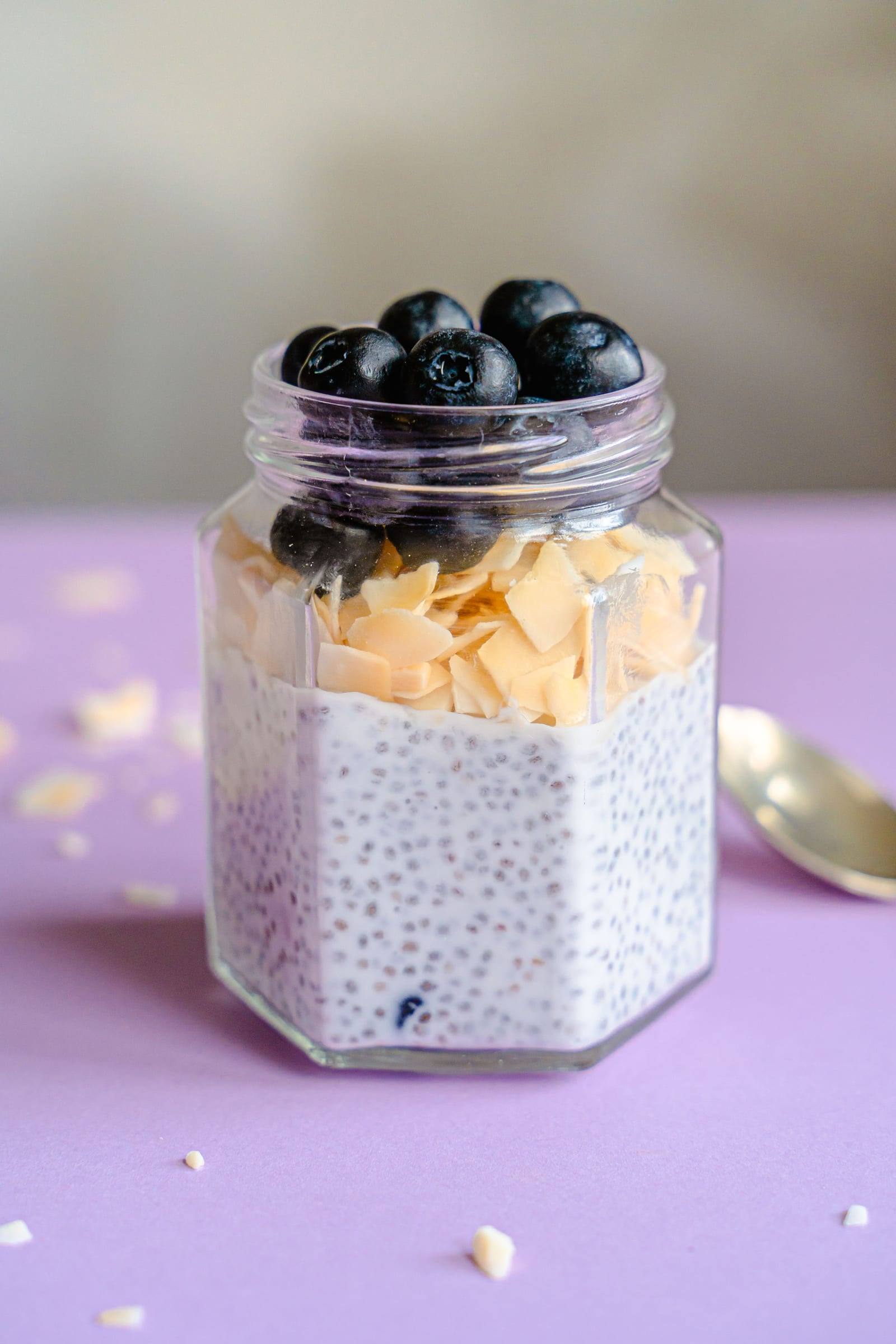 Chia-Pudding im Glas, belegt mit Mandelblättchen und Heidelbeeren