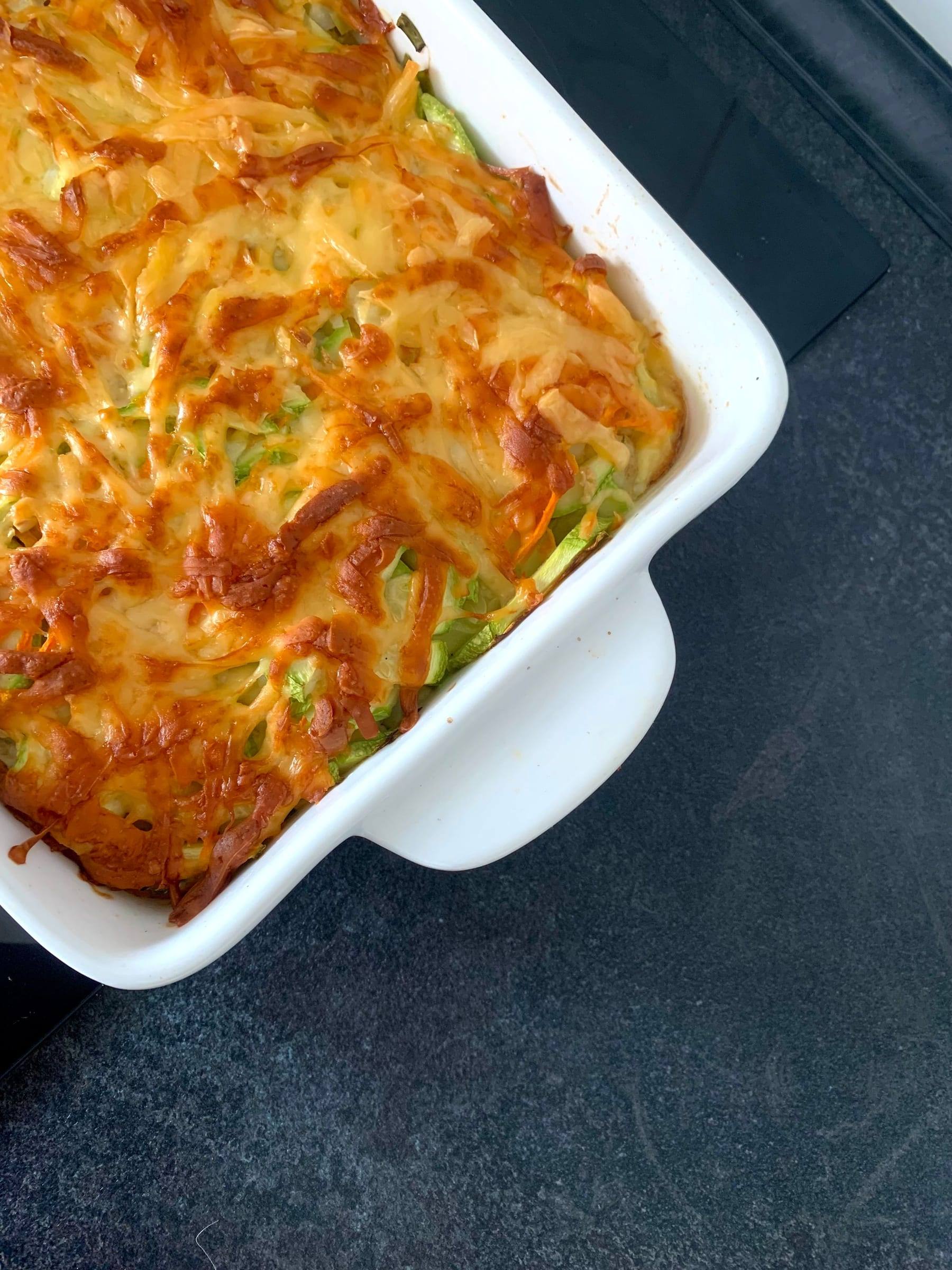 Auflauf mit goldbrauner Käsekruste und Zucchini in einer weißen Form