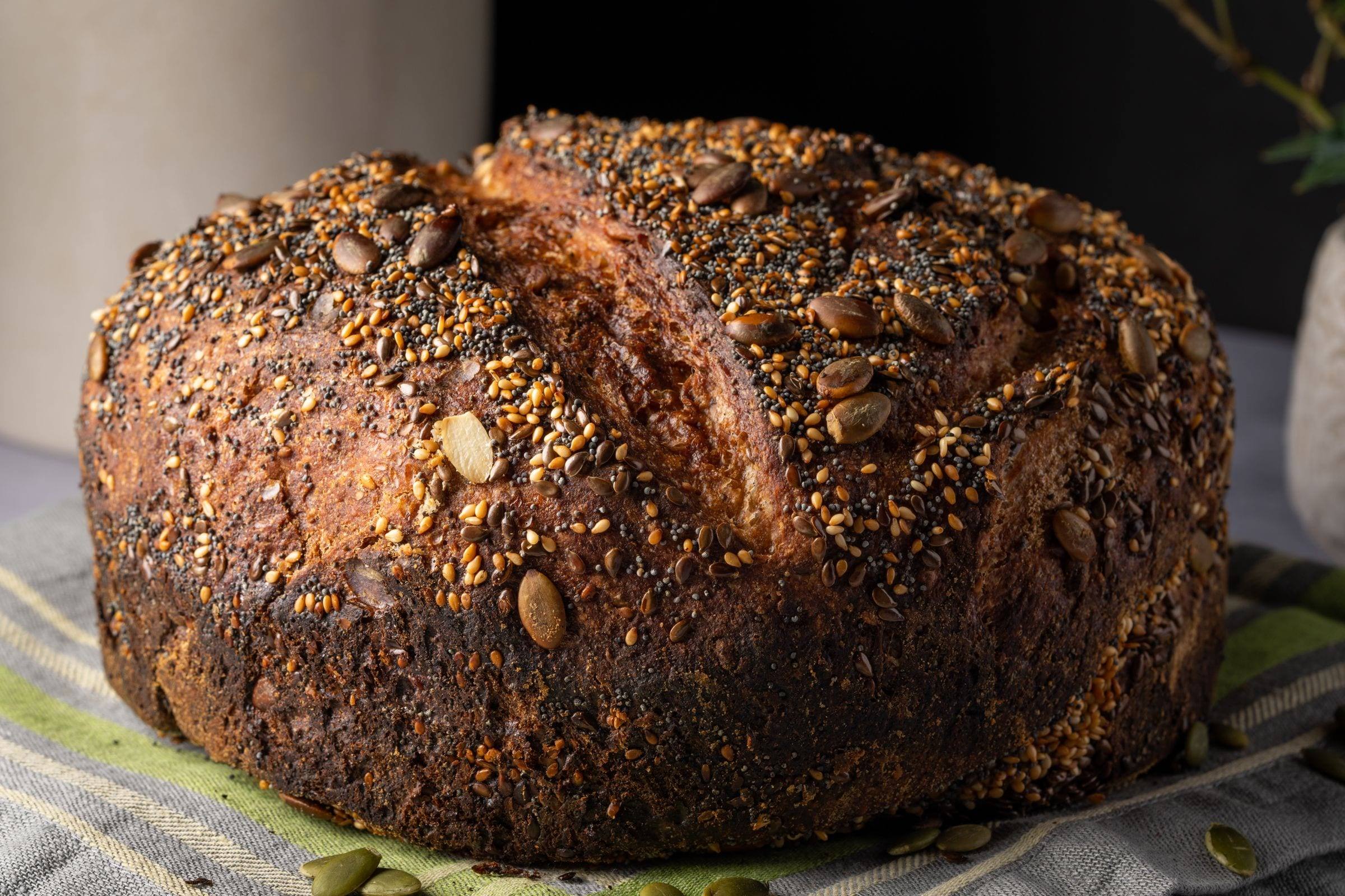 Rundes Brot mit Kürbis- und Sesamkernen auf der dunklen Kruste