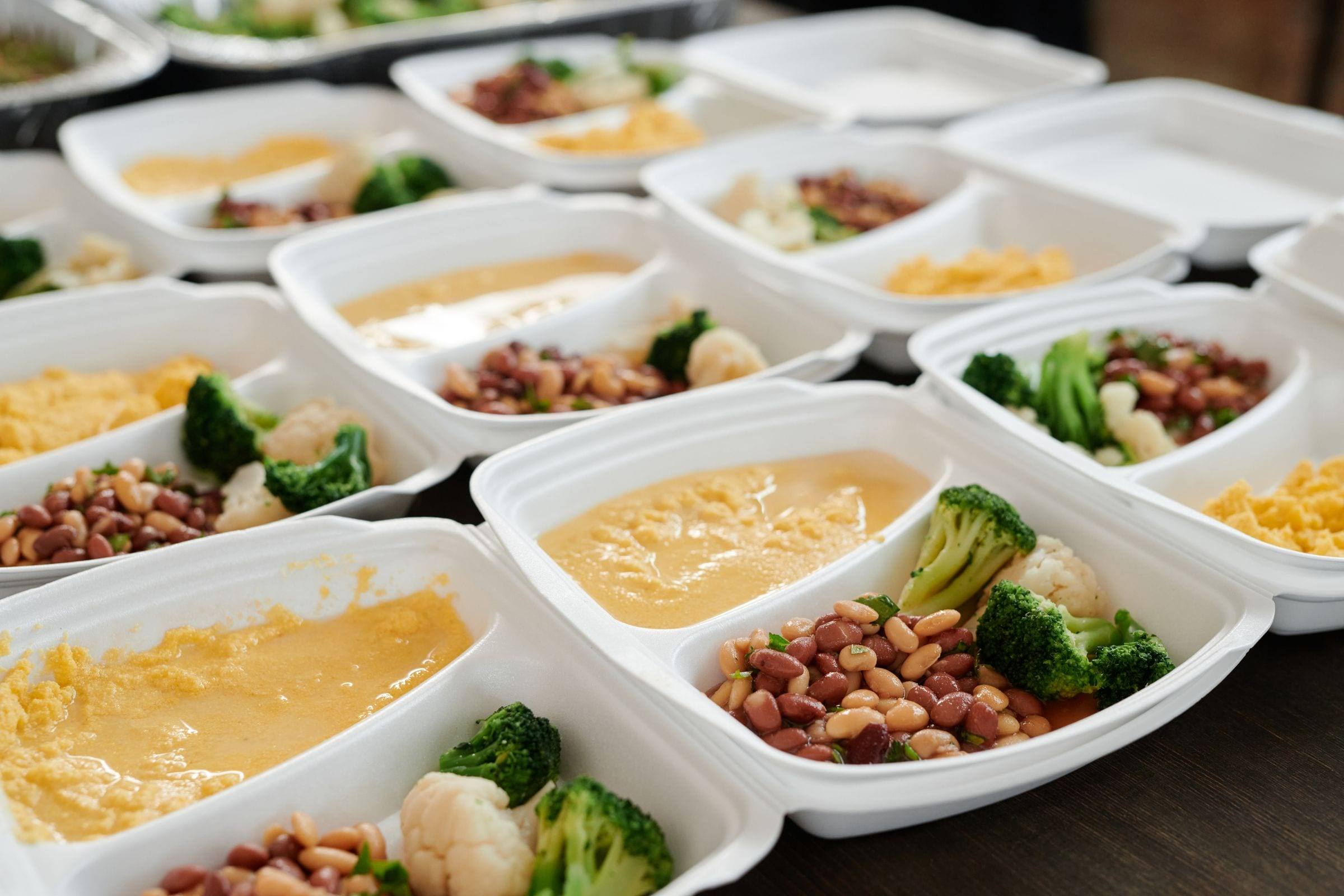 Vorbereitete Portionen mit Brokkoli, Ei und Beilagen in Einwegschalen