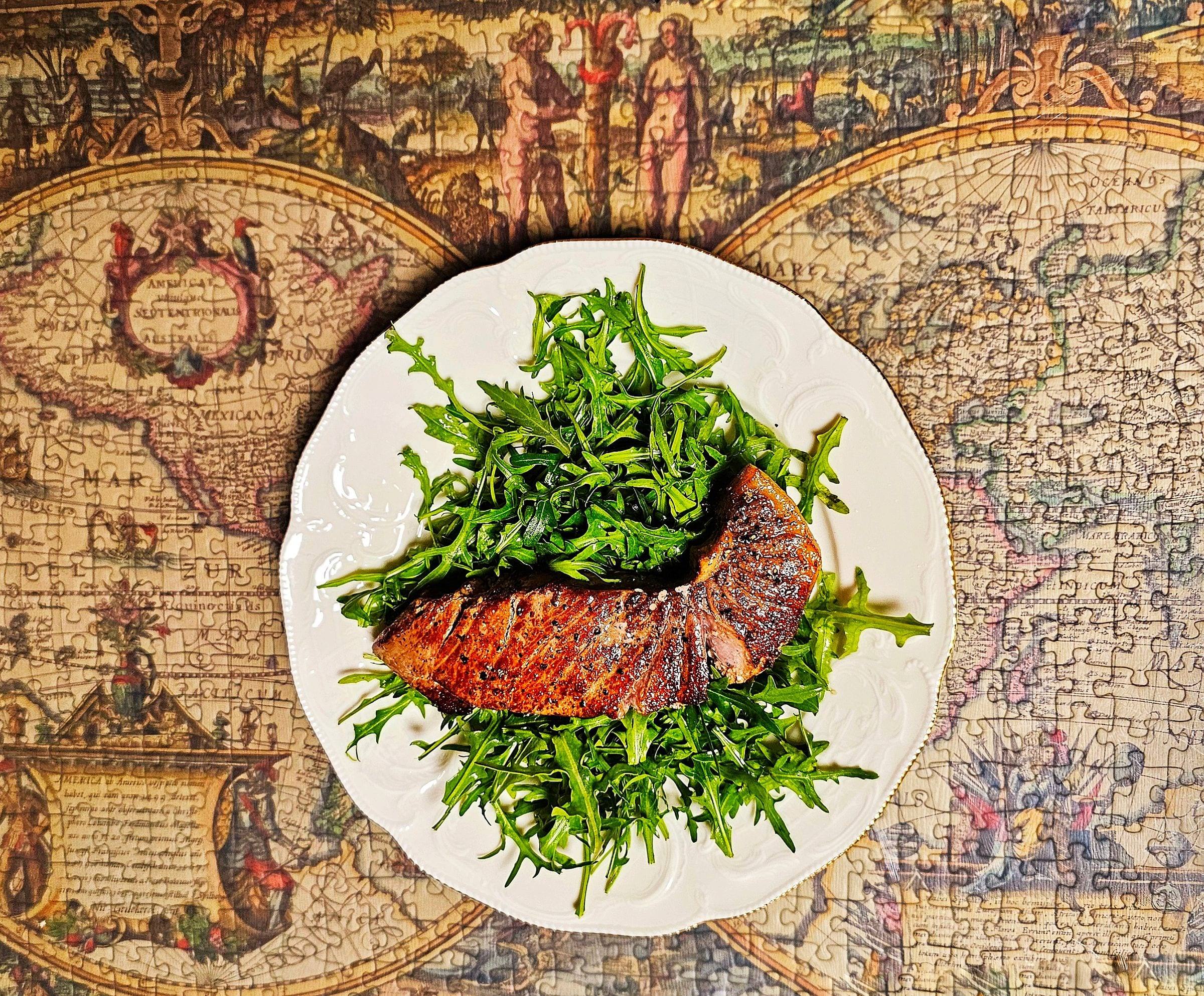 Gebratenes Lachsfilet auf einem Bett aus Rucola auf einem weißen Teller